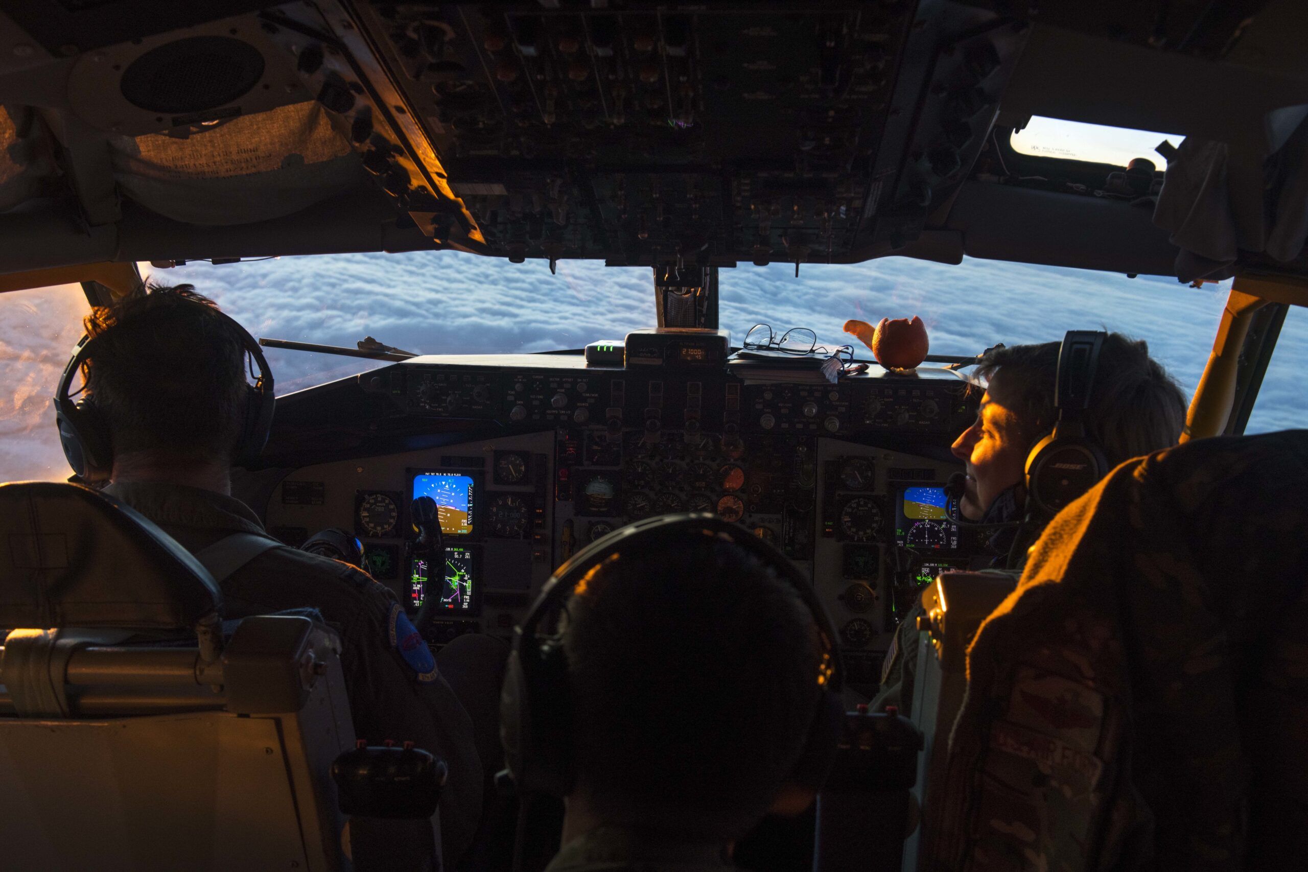 pilot and copilot sit in the cockpit of an aircraft in the air.